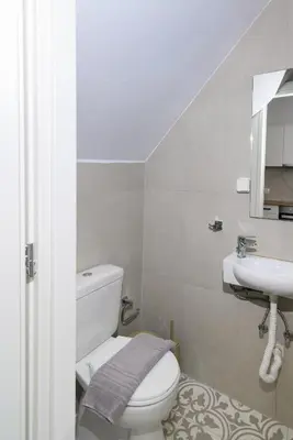 a bathroom with a white toilet and a sink at Kiki House in Rhodes Town