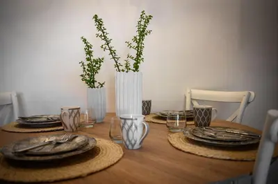 a wooden table with plates and vases with plants at Kiki House in Rhodes Town