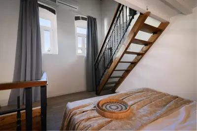 a bedroom with a bed and a stair case at Kiki House in Rhodes Town