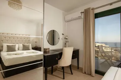 a bedroom with a desk and a bed with a mirror at Villa Kiki, Kiotari in Asklipiḯon