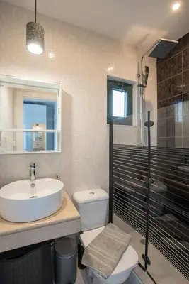 a bathroom with a sink and a toilet and a shower at Villa Kiki, Kiotari in Asklipiḯon