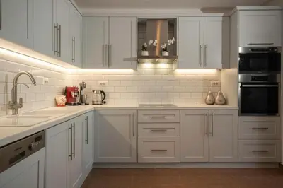 a white kitchen with white cabinets and appliances at Villa Kiki, Kiotari in Asklipiḯon