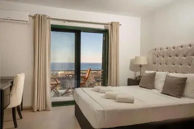 a bedroom with a bed and a large window at Villa Kiki, Kiotari in Asklipiḯon