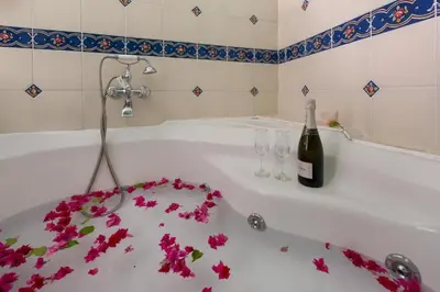 a bath tub with a bottle of wine and flowers on it at Nikos Takis Boutique Fashion hotel in Rhodes Town