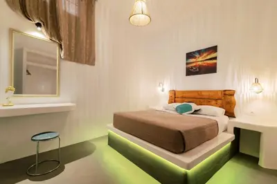 a bedroom with a bed and a stool in a room at Nora's ixia summer house in Ialyssos