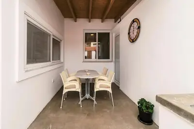 a dining room with a table and chairs and a clock at Nora's ixia summer house in Ialyssos