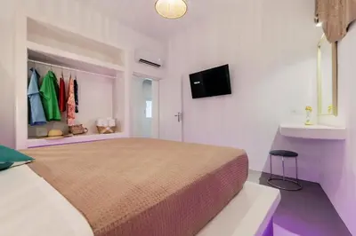 a bedroom with a large bed and a tv at Nora's ixia summer house in Ialyssos
