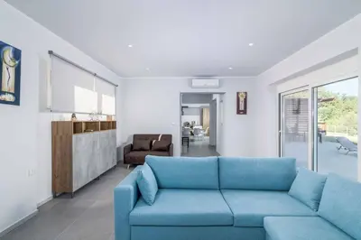 a living room with a blue couch in a room at Villa Anastazia in Koskinou
