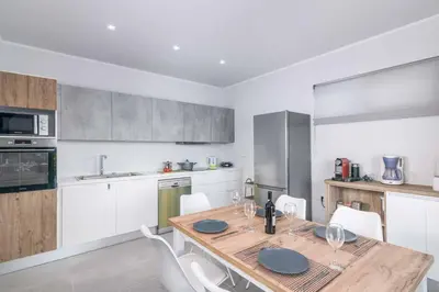a kitchen with a wooden table and white cabinets at Villa Anastazia in Koskinou