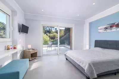 a bedroom with a bed and a view of a patio at Villa Anastazia in Koskinou
