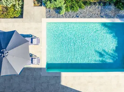 an overhead view of a swimming pool with an umbrella at Villa Anastazia in Koskinou