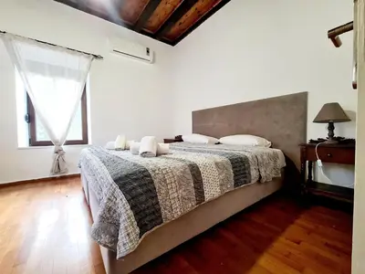 a bedroom with a bed with a blanket and a window at Shades of Wood Old Town in Rhodes Town