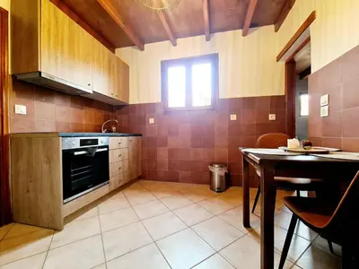 a kitchen with a stove and a table in it at Shades of Wood Old Town in Rhodes Town