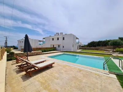 a villa with a swimming pool and a house at The 4th Seaview Villas in Kiotari