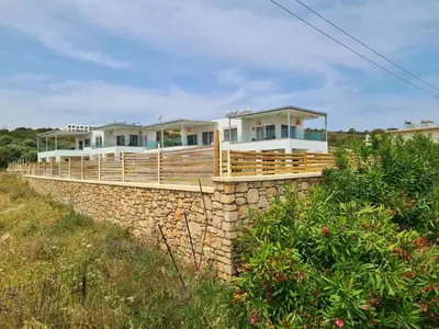a house on top of a stone wall at The 4th Seaview Villas in Kiotari