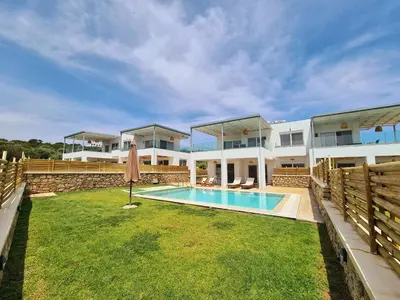 a large house with a swimming pool in the yard at The 4th Seaview Villas in Kiotari
