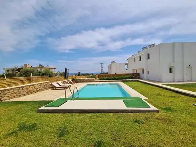a swimming pool in a yard next to a building at The 4th Seaview Villas in Kiotari
