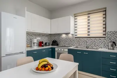 a kitchen with blue cabinets and a plate of fruit on a table at Rodini Anassa in Rhodes Town