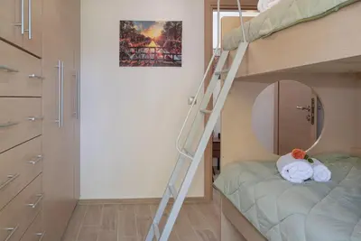 a bunk bed with a ladder in a room at Filerimos City Center Apt in Ialysos Rhodes in Ialyssos