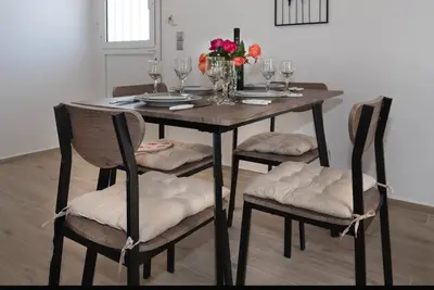 a dining room table with four chairs and a vase of flowers at Filerimos City Center Apt in Ialysos Rhodes in Ialyssos