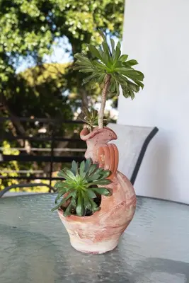 a plant in a vase sitting on a table at Filerimos City Center Apt in Ialysos Rhodes in Ialyssos