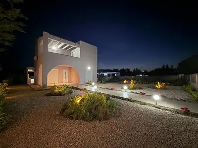 a house with a lit up yard at night at Azure Dreams Villa with pool - Haraki beach in Haraki