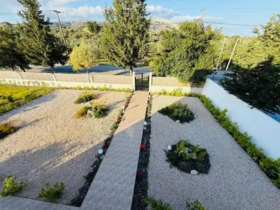 a garden with some plants and flowers on a sidewalk at Azure Dreams Villa with pool - Haraki beach in Haraki