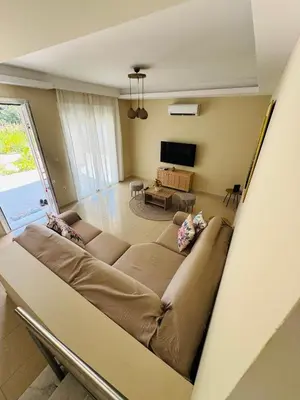 a living room with a couch and a tv at Azure Dreams Villa with pool - Haraki beach in Haraki