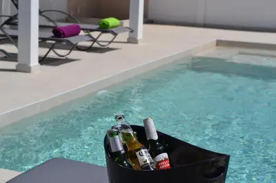 a basket of wine bottles sitting next to a swimming pool at Azure Dreams Villa with pool - Haraki beach in Haraki