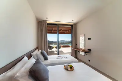 a bedroom with a bed and a large window at Under The Sun on Faliraki Hill in Kalithies