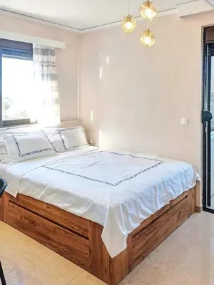 a bedroom with a large bed with white sheets at 7-Modern city center studio with sea view! in Rhodes Town