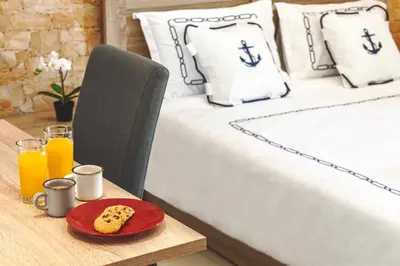 a bed with a table with a plate of corn on a table sidx sidx sidx at 5- Luxury suite for 4 in the most central part of Rhodes! in Rhodes Town