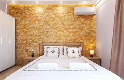 a bedroom with a bed and a brick wall at 5- Luxury suite for 4 in the most central part of Rhodes! in Rhodes Town