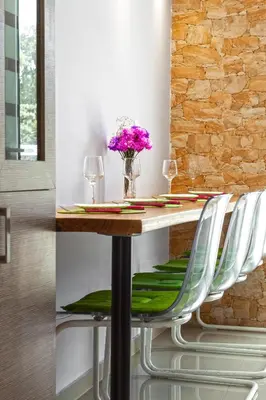 a dining room table with chairs and a vase of flowers at 5- Luxury suite for 4 in the most central part of Rhodes! in Rhodes Town