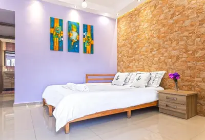 a bedroom with a bed and a stone wall at 5- Luxury suite for 4 in the most central part of Rhodes! in Rhodes Town