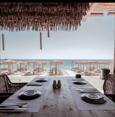 a dining table with chairs and a view of the beach at Melograno di Rodi 7 in Rhodes Town