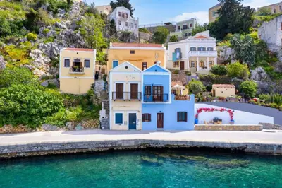 a house on a hill next to a body of water at Evgenias Sea House in Symi