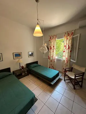 a bedroom with two green beds and a window at Summerhouse Marianna in Ixia