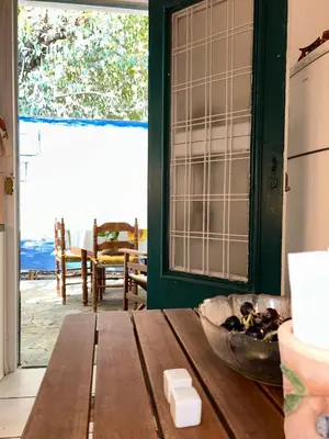 a kitchen with a wooden table and a door to a patio at Summerhouse Marianna in Ixia