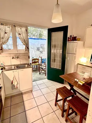 a kitchen with a table and a dining room at Summerhouse Marianna in Ixia
