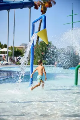 a young boy is playing in a water park at Blue Bay Beach Resort in Ialyssos