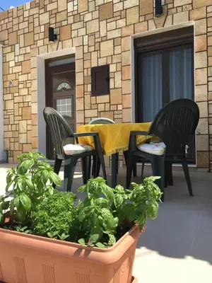 a patio with chairs and a table and some lettuce at Stone House Retreat in Kalavárda