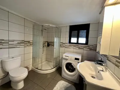 a bathroom with a toilet a sink and a washing machine at Stone House Retreat in Kalavárda