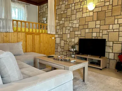 a living room with a couch and a tv at Stone House Retreat in Kalavárda