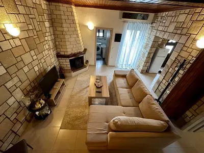 a living room with a couch and a fireplace at Stone House Retreat in Kalavárda