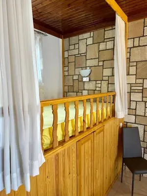 a room with a balcony with a window at Stone House Retreat in Kalavárda