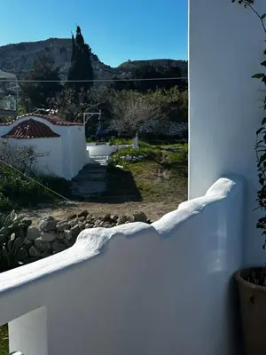 a white fence with a view of a yard at Hermes Seaview House in Archangelos