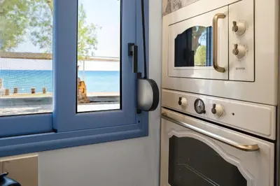 a kitchen with a window next to a oven at Hermes Seaview House in Archangelos