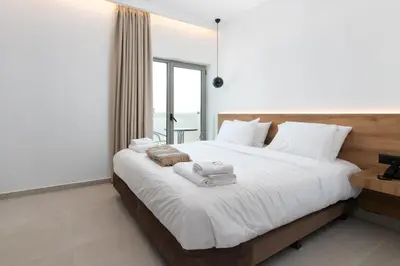 a bedroom with a large bed with towels on it at Rodos White in Rhodes Town