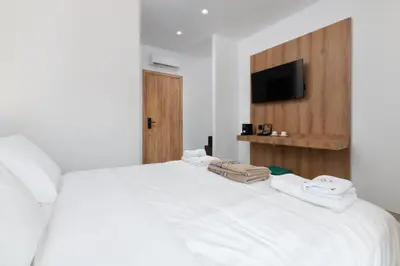a bedroom with a white bed with towels on it at Rodos White in Rhodes Town
